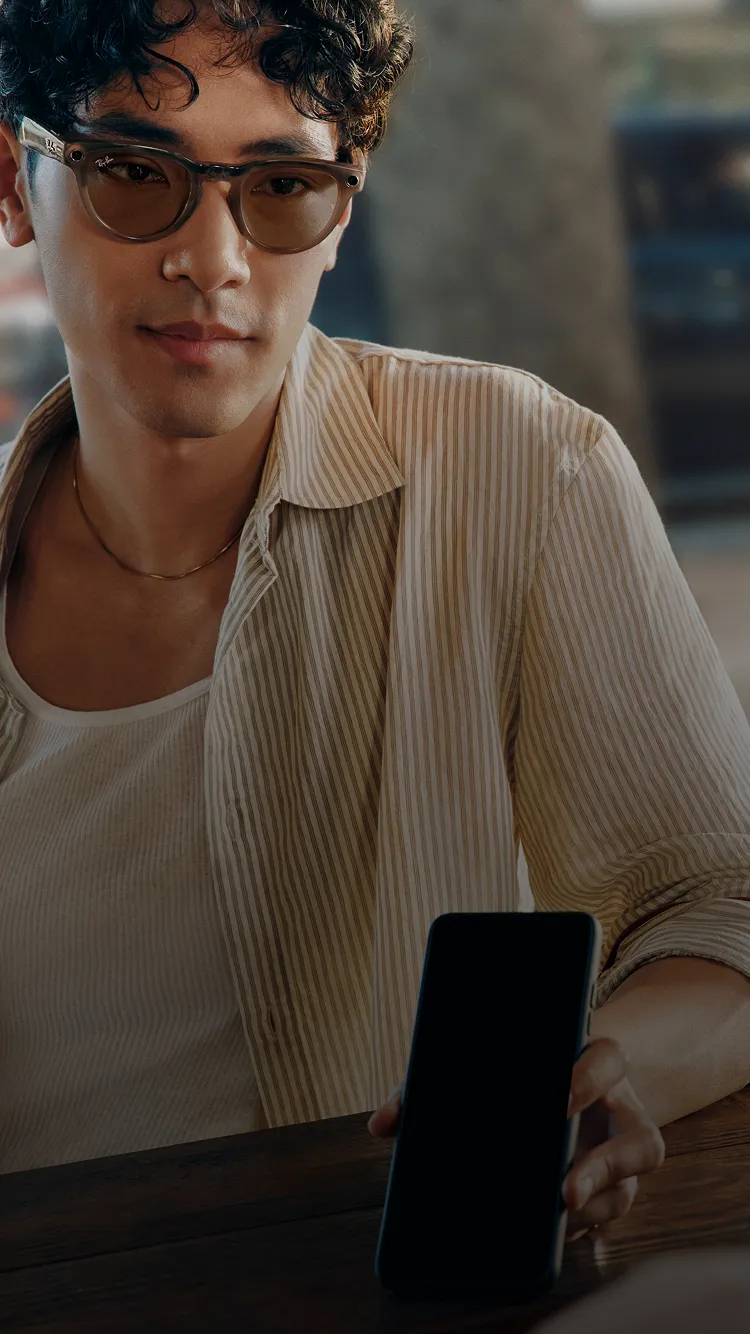 A person wearing Ray-Ban Meta glasses with a phone during a live translation experience.